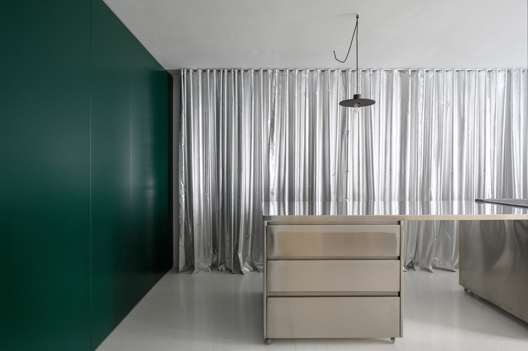 Room with dark green wall and silver curtains
