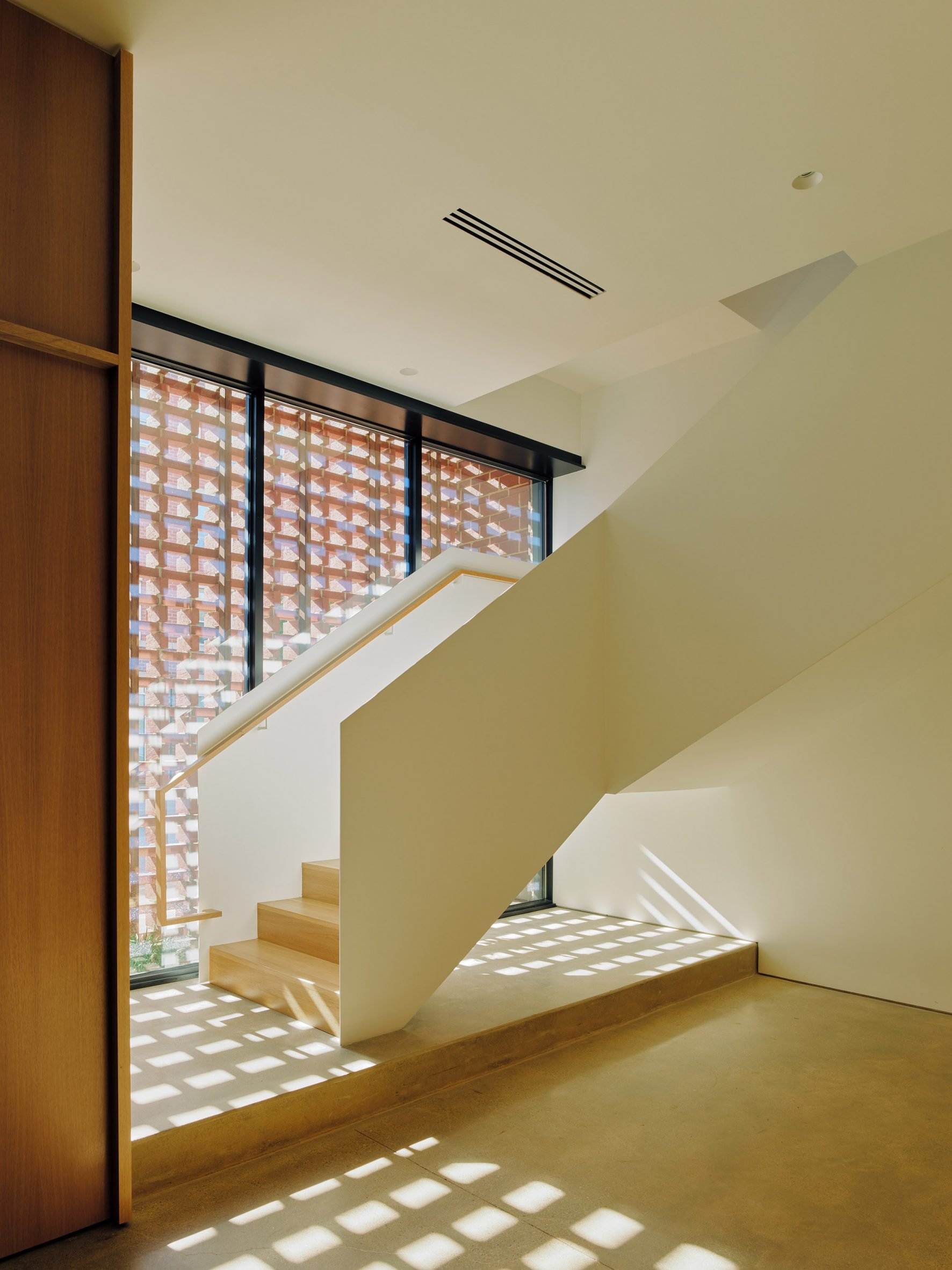 Staircase with light filtering through by Range Design & Architecture