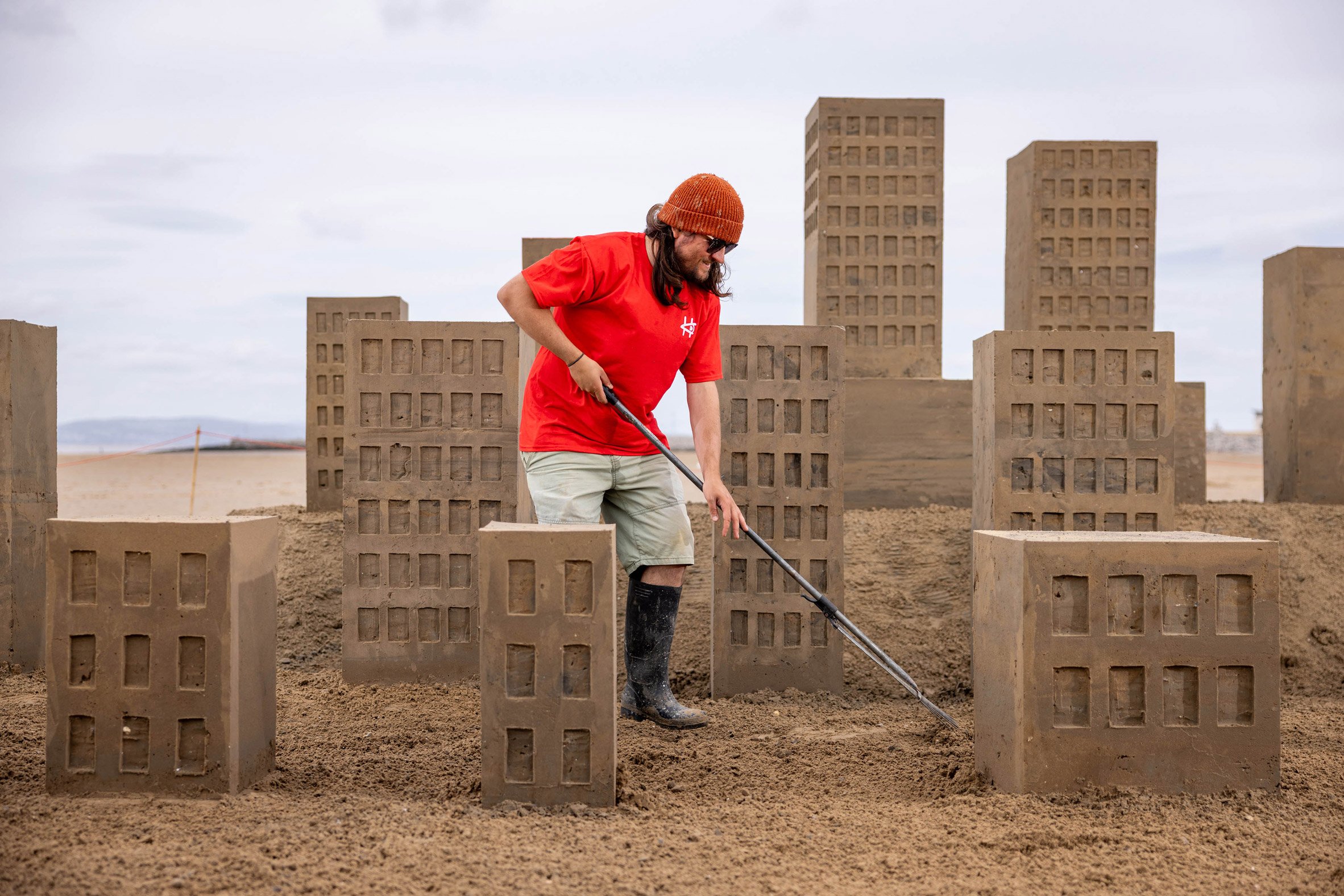 Man on beach with sand castles