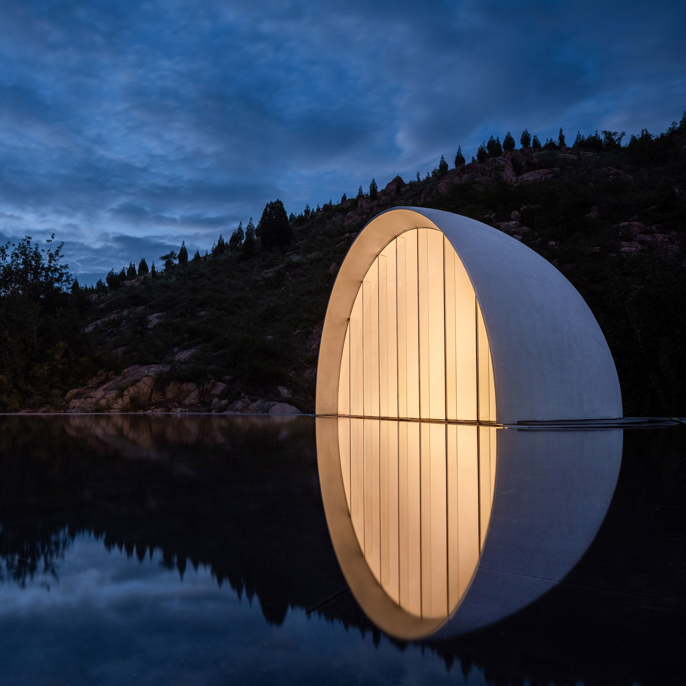 A half domed volume emerges from a pool of water