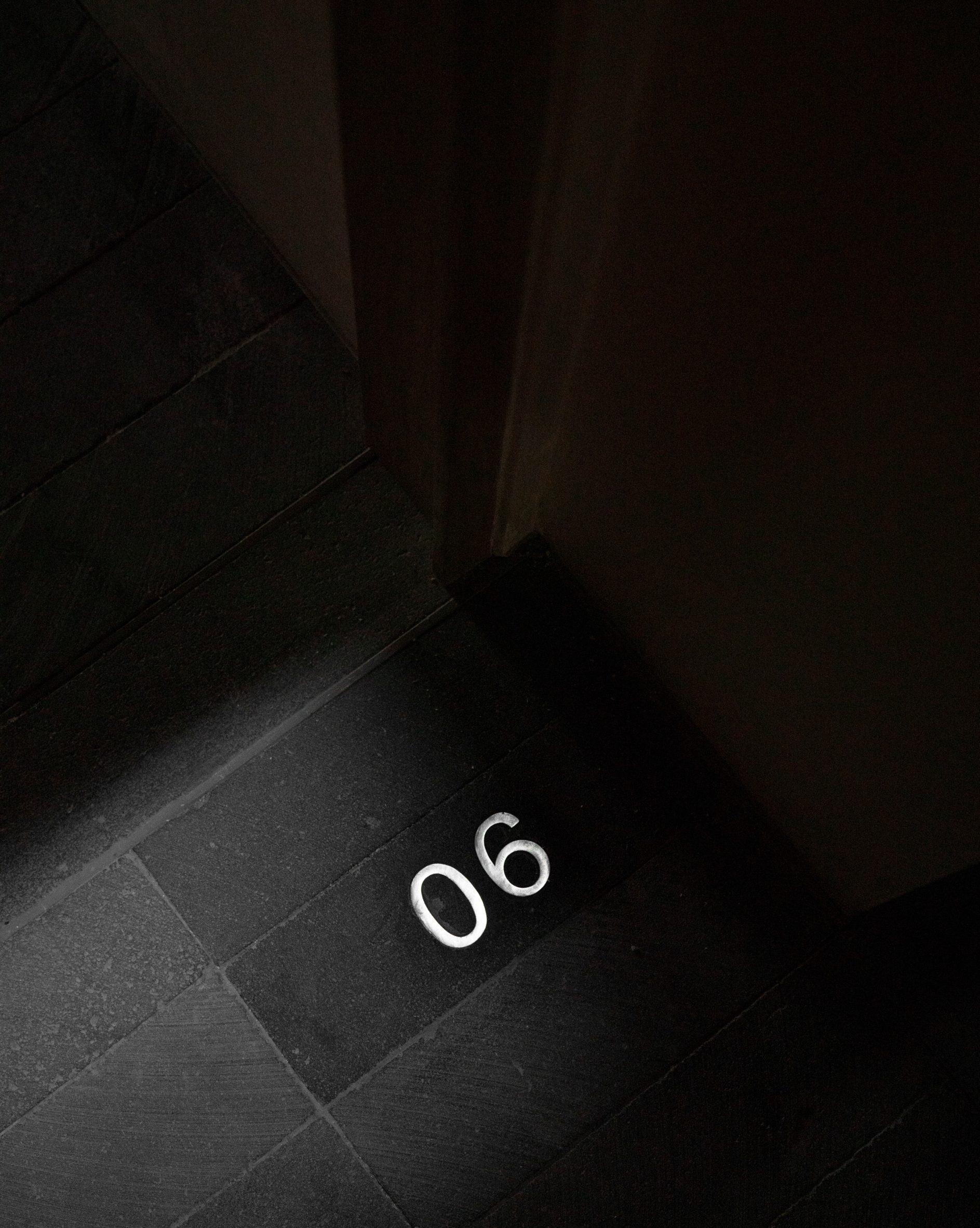 Guest room number etched into a dark stone floor tile