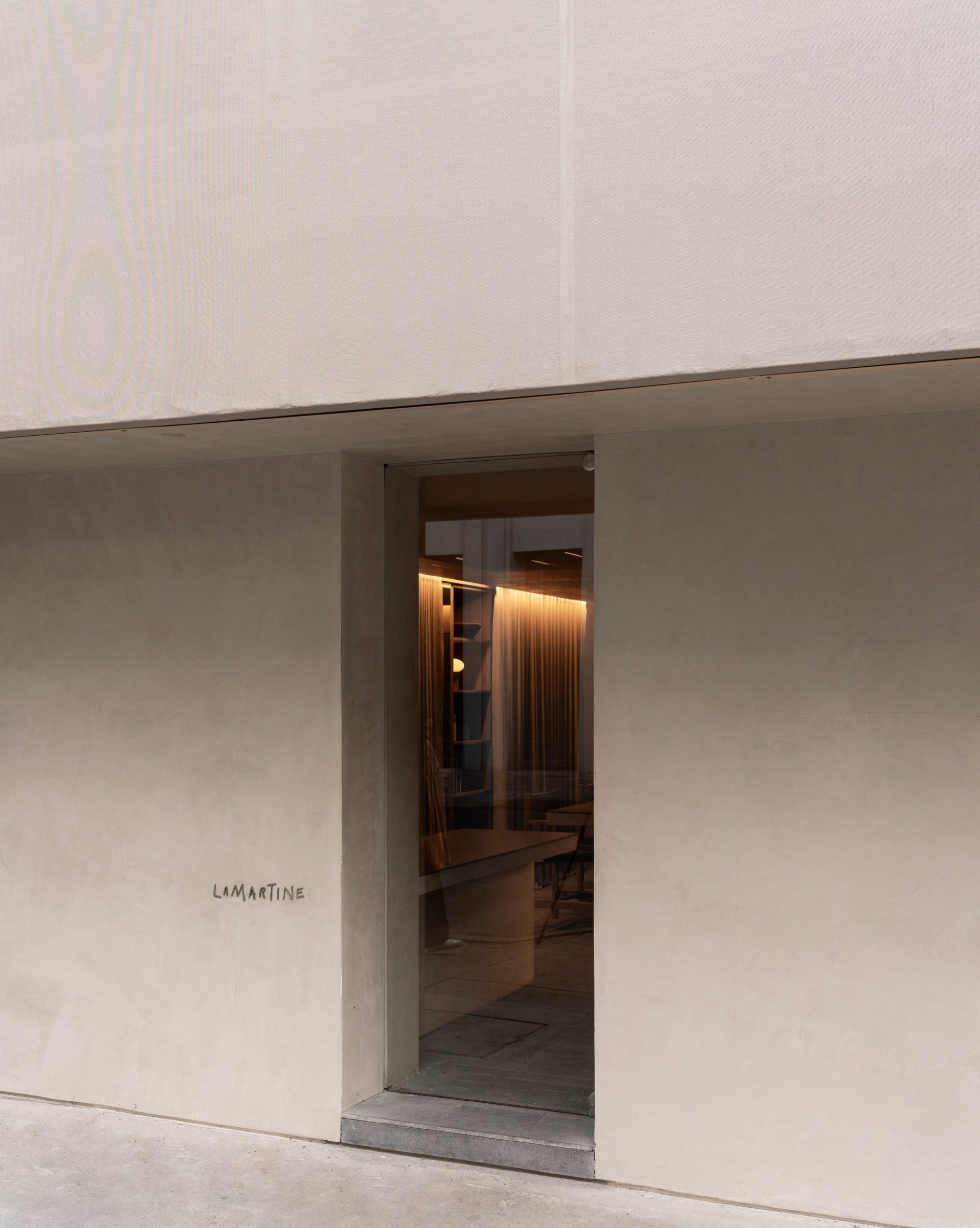 Hotel entrance via a glass door set into a textured plaster wall