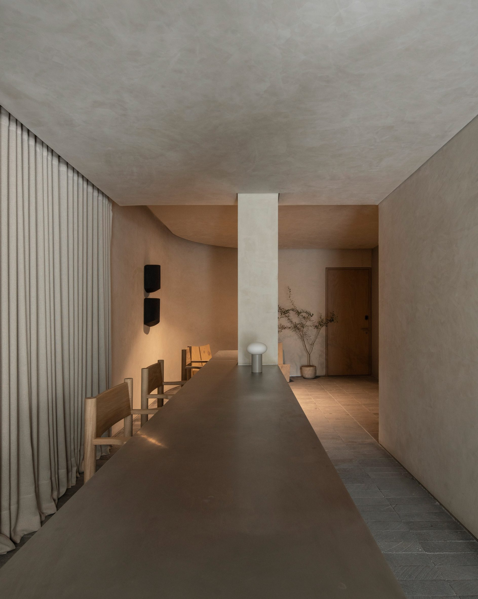A long table anchored by a structural column forms a reception desk